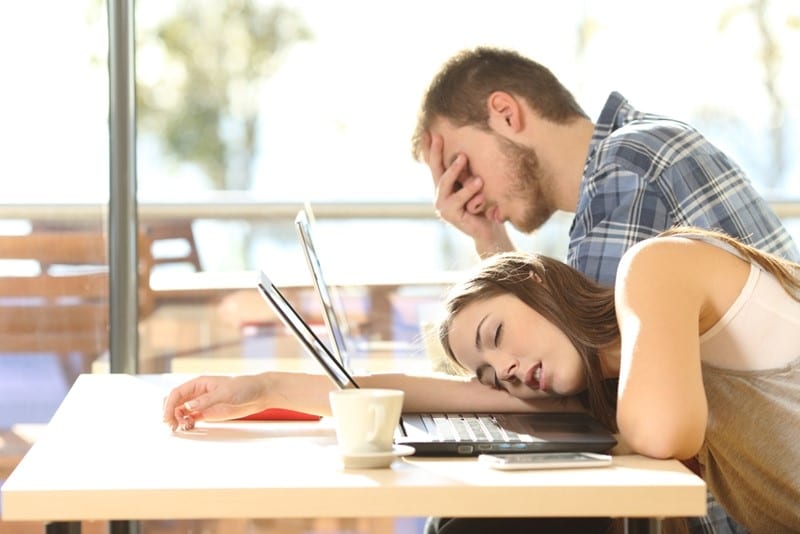 two people falling asleep with laptops