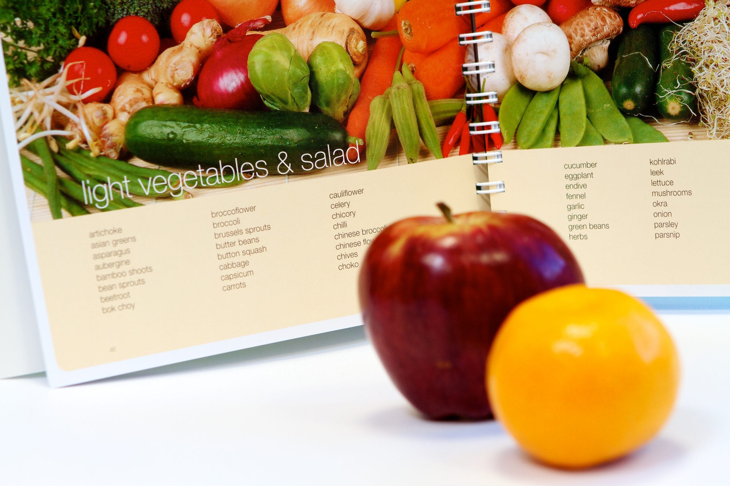 apple and mandarine in front of food book