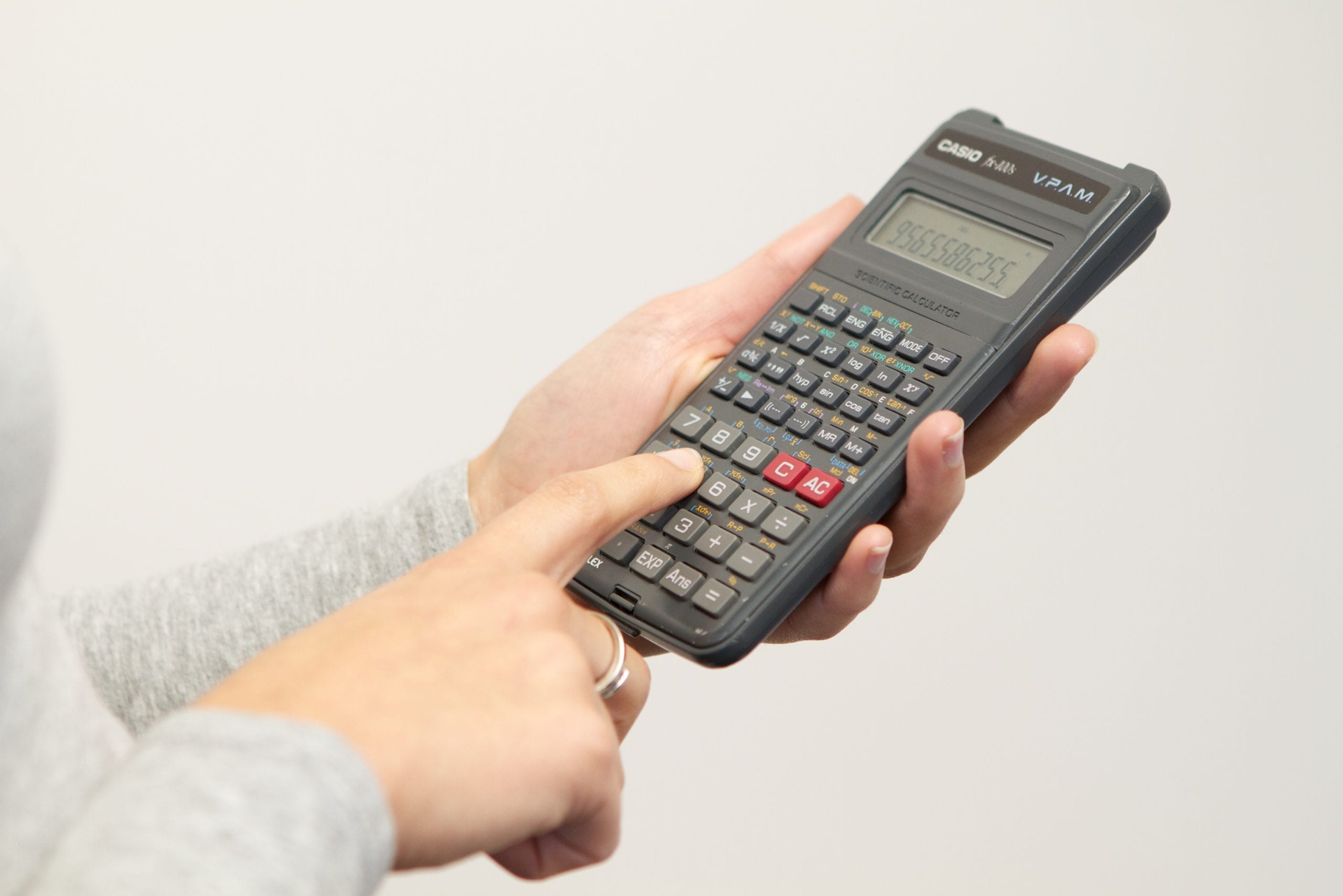 image of hands and person using calculator