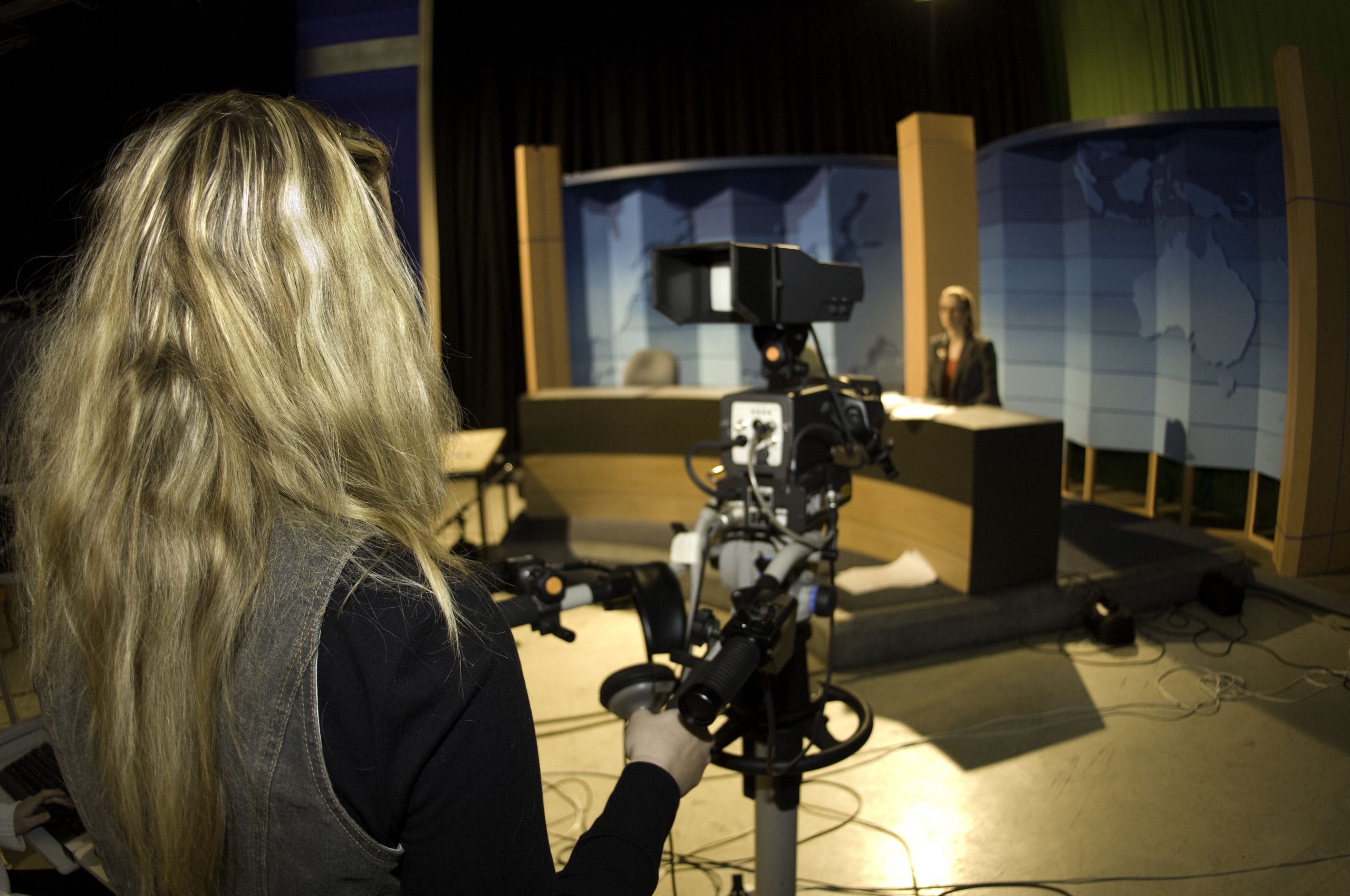 Student standing behind TV news camera