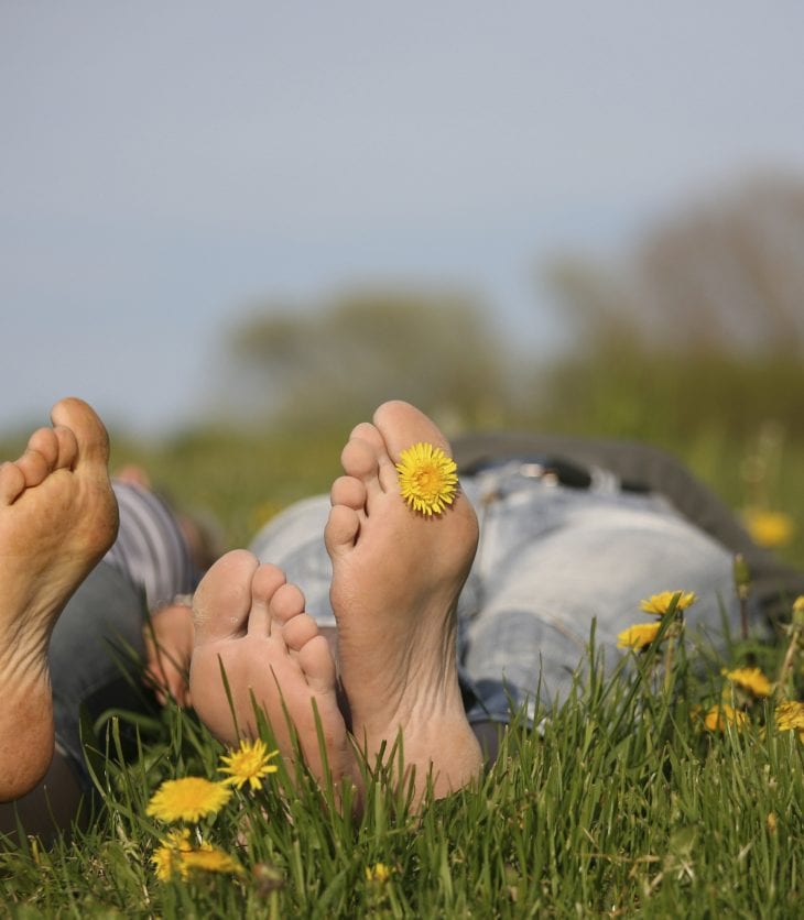 two sets of feet lying in the grass