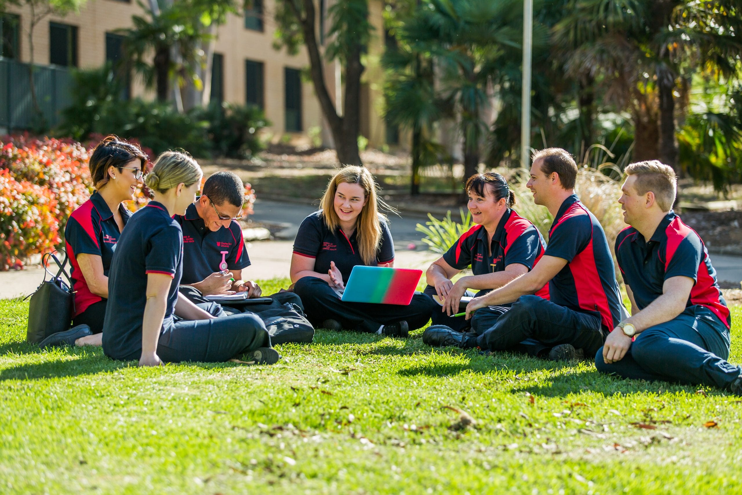Students sitting on the grass in a circle talking