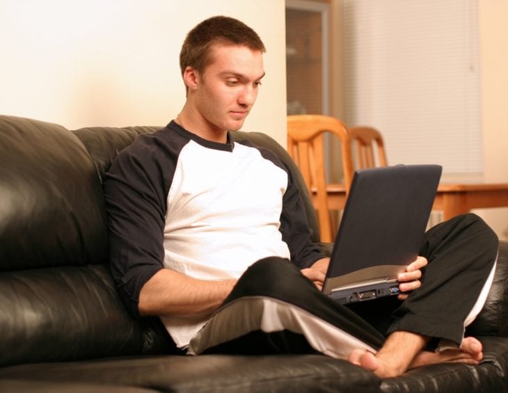 Male student studying on laptop