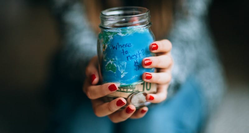 Girl holding jar full of coins for adventures
