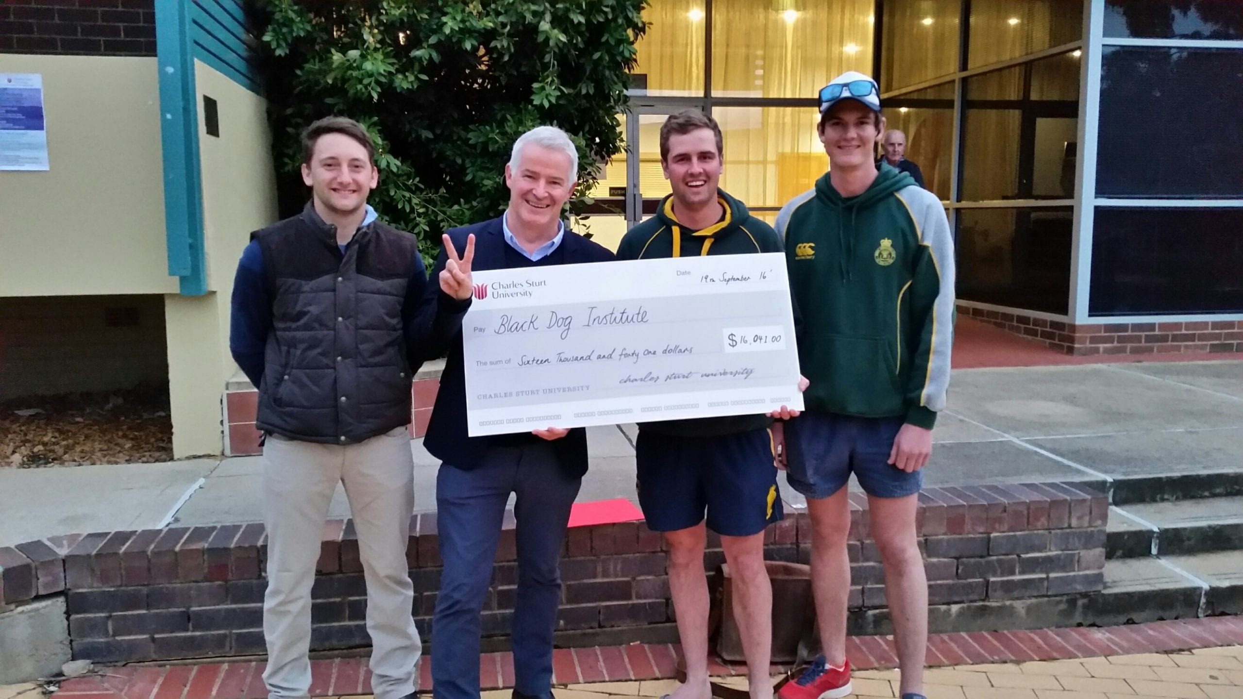 CSU fundraisers proudly hold a cheque to be donated to charity