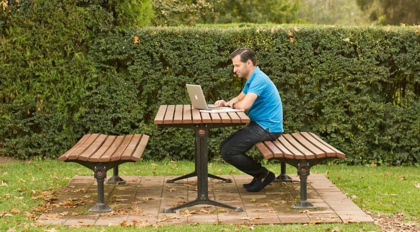 CSU online student studying in the park on his laptop.