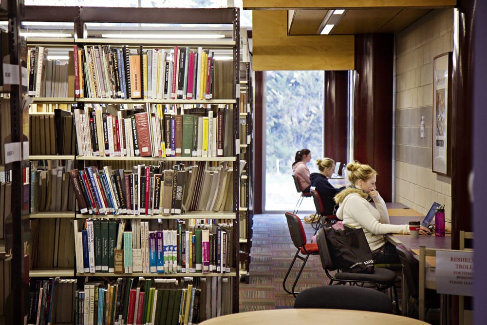 students studying at desks in the library