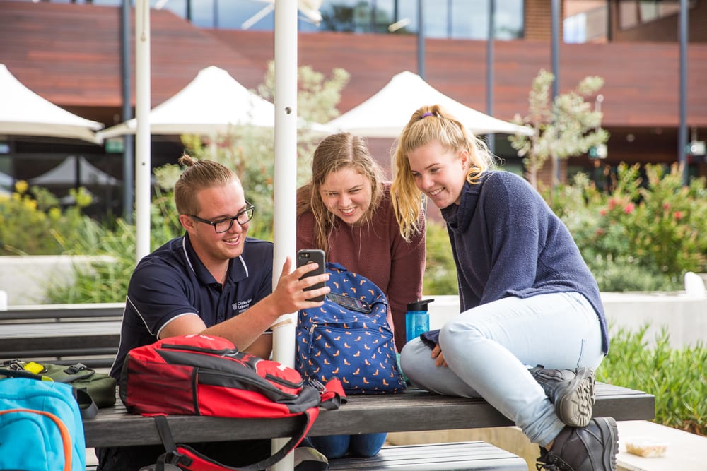 Group of students together looking at mobile phone