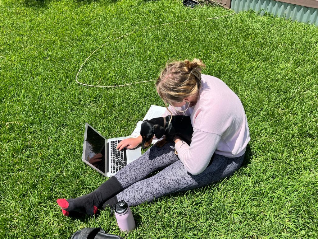 Megan studying outside with her puppy.