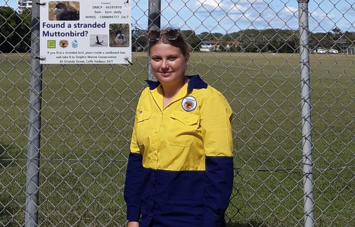 Woman standing in front of a fence.